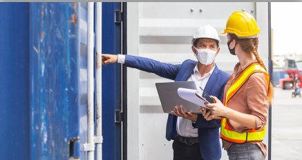 Dois técnicos com capacete fazendo inspeção em uma obra